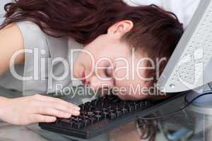 Businesswoman sleeping on the keyboard in the office
