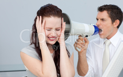 Businessman shouting through a megaphone at his colleague