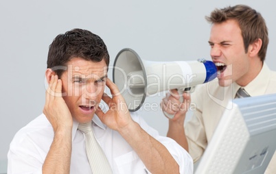 Businessman yelling through a megaphone at his colleague