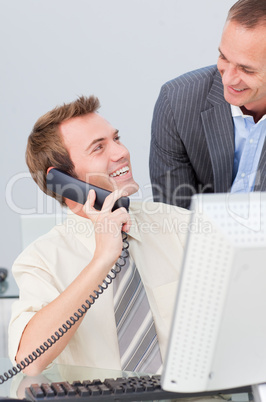 Businessman on phone talking to his colleague in the office