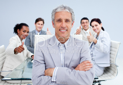 Happy businessman leading his happy team with thumbs up
