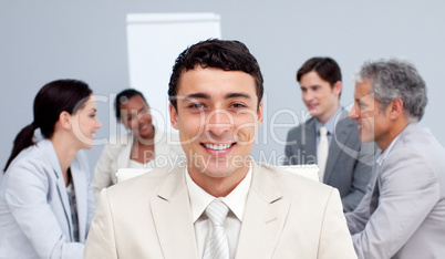 Smiling businessman sitting in front of his team in a meeting