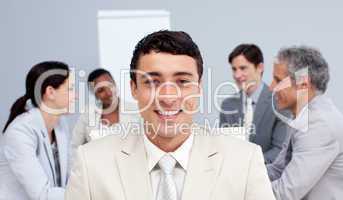 Smiling businessman sitting in front of his team in a meeting