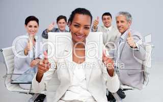 Afro-American businesswoman and her team with thumbs up