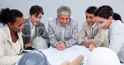 Engineers in a meeting studying plans