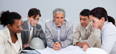 Architect manager in a meeting with his team studying plans