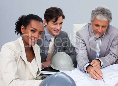 Afro-American female engineer studying plans in a meeting