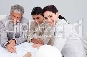 Portrait of a female engineer studying plans with her colleagues