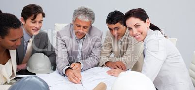 Beautiful female architect studying plans with her colleagues