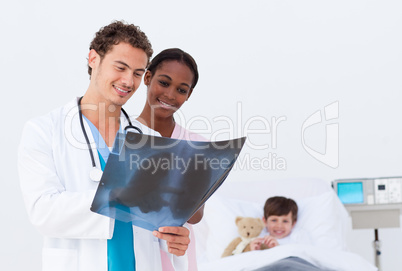 Doctor and nurse examining an x-ray in a bedroom's kid