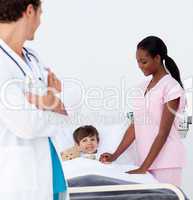 Pediatrician and nurse attending to a little boy