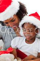 Afro-American mother and daughter opening a Christmas gift