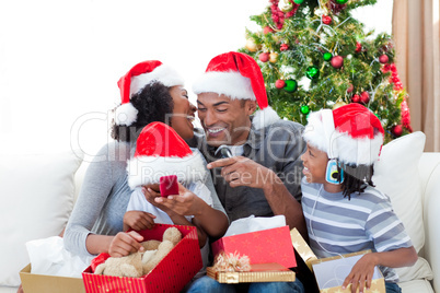 Happy Afro-American family having fun with Christmas presents