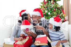 Happy Afro-American family having fun with Christmas presents