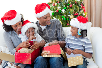 Happy Afro-American family opening Christmas presents