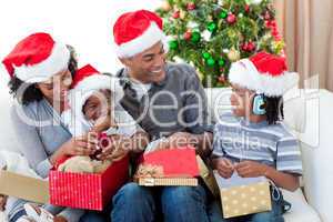 Happy Afro-American family opening Christmas presents
