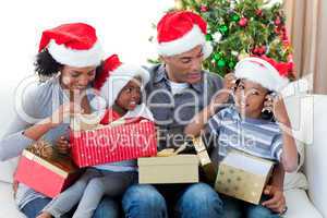 Happy Afro-American family playing with Christmas presents