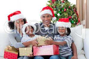 Smiling Afro-American family sharing Christmas presents