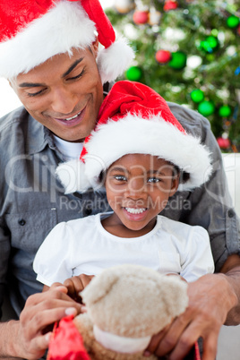Happy little girl playing with a Christmas gift with her father