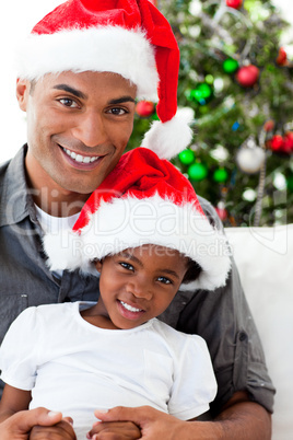 Afro-American dad and daughter wearing a Christmas hat