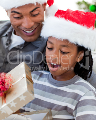 Portrait of an Afro-American father and son opening a Christmas