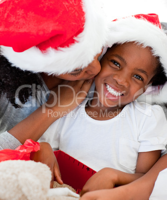 Mother kissing her daughter at Christmas