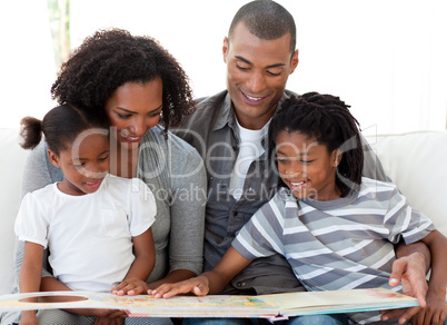 Afro-American family reading a book in the living-room