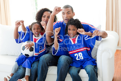 Afro-American family celebrating a goal at home