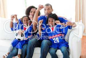 Afro-American family celebrating a goal at home