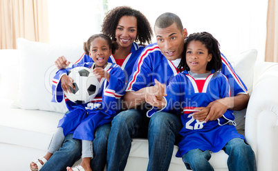 Afro-American family watching a football match at home