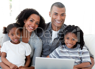 Happy Afro-American family using a laptop in the living-room