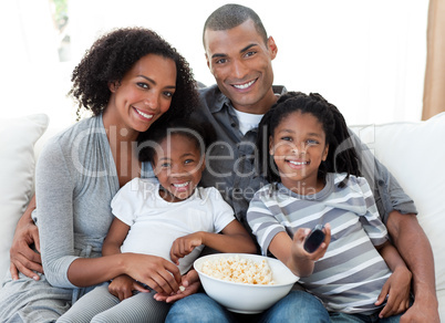 Afro-American family watching television at home
