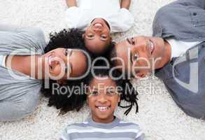 Smiling Afro-American young family lying on floor