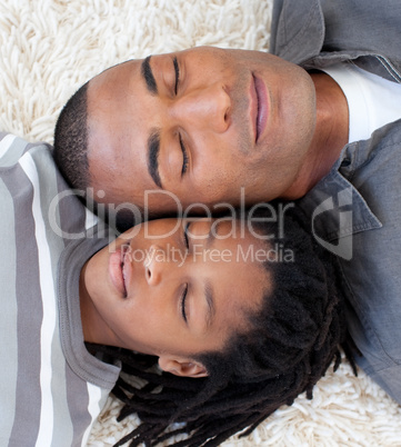 Portrait of Afro-American father and son sleeping on the floor