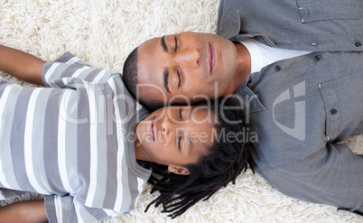 Afro-American father and son sleeping on the floor
