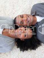 Smiling Afro-American couple lying on the floor