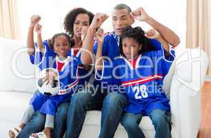 Excited Afro-American family watching a football match
