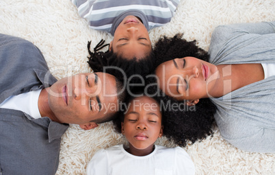 Afro-American family sleeping on floor with heads together