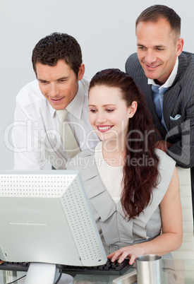Three business people using a computer