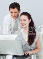 Businessman helping a businesswoman with a computer