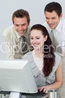 Businessmen helping a businesswoman with a computer