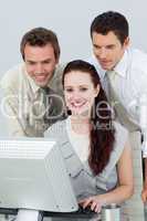 Three young business people using a computer