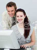 Beautiful businesswoman and attractive businessman using a compu