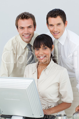 Smiling business people using a computer in the office