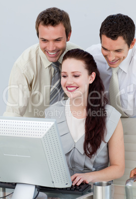 Businessmen helping her colleague with a computer