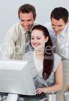 Businessmen helping her colleague with a computer