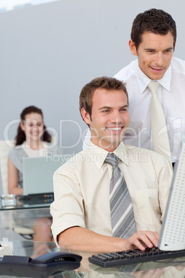 Businessmen working together with a computer in a company