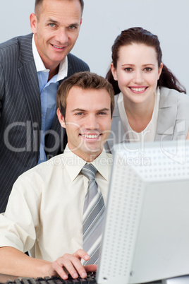 Smiling business people working together with a computer