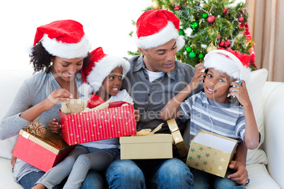 Happy Afro-American family playing with Christmas presents