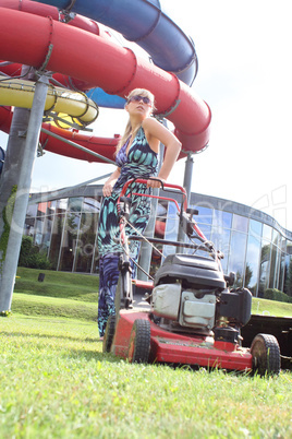 young blond woman with a lawnmower